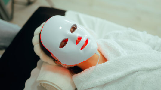 Person mit LED-Maske auf dem Gesicht